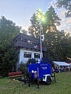 Bild eines Anhänger Lichtmast 20 kVA mit ausgefahrenem Lichtmast und eingeschalteten Lampen